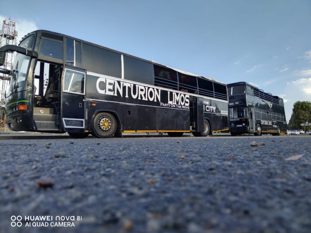 Two open-top party buses from Centurion Limos filled with excited passengers heading to Ultra South Africa 2024.
